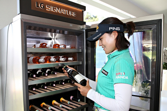 LG전자가 LPGA 메이저 골프대회인 '에비앙 챔피언십'에서 프리미엄 'LG 시그니처'를 적극 알리고 있다. 전인지 선수가 LG 시그니처 와인셀러를 체험하고 있다. <LG전자 제공>
